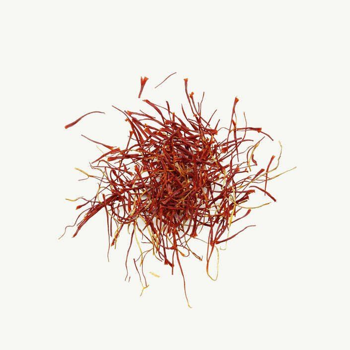 A pile of saffron threads on a white background.