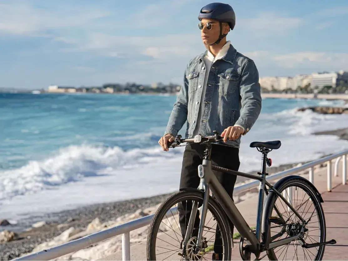 man with a Tenways Electric Bike on a sidewalk by the ocean