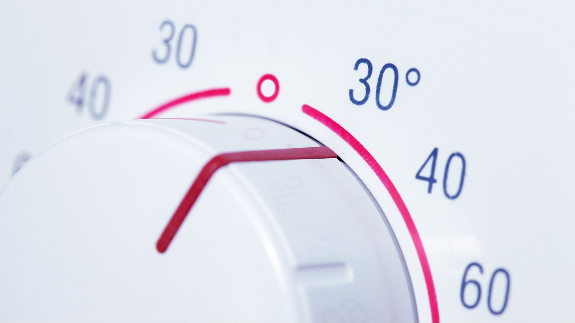 A close up of a thermostat showing the temperature at 30 degrees