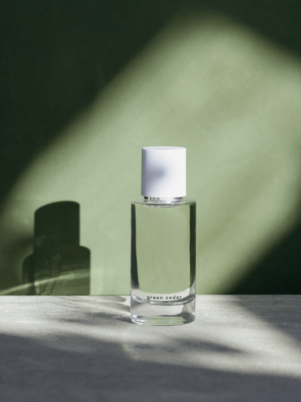 a bottle of natural Abel perfume is sitting on a table in front of a green wall .