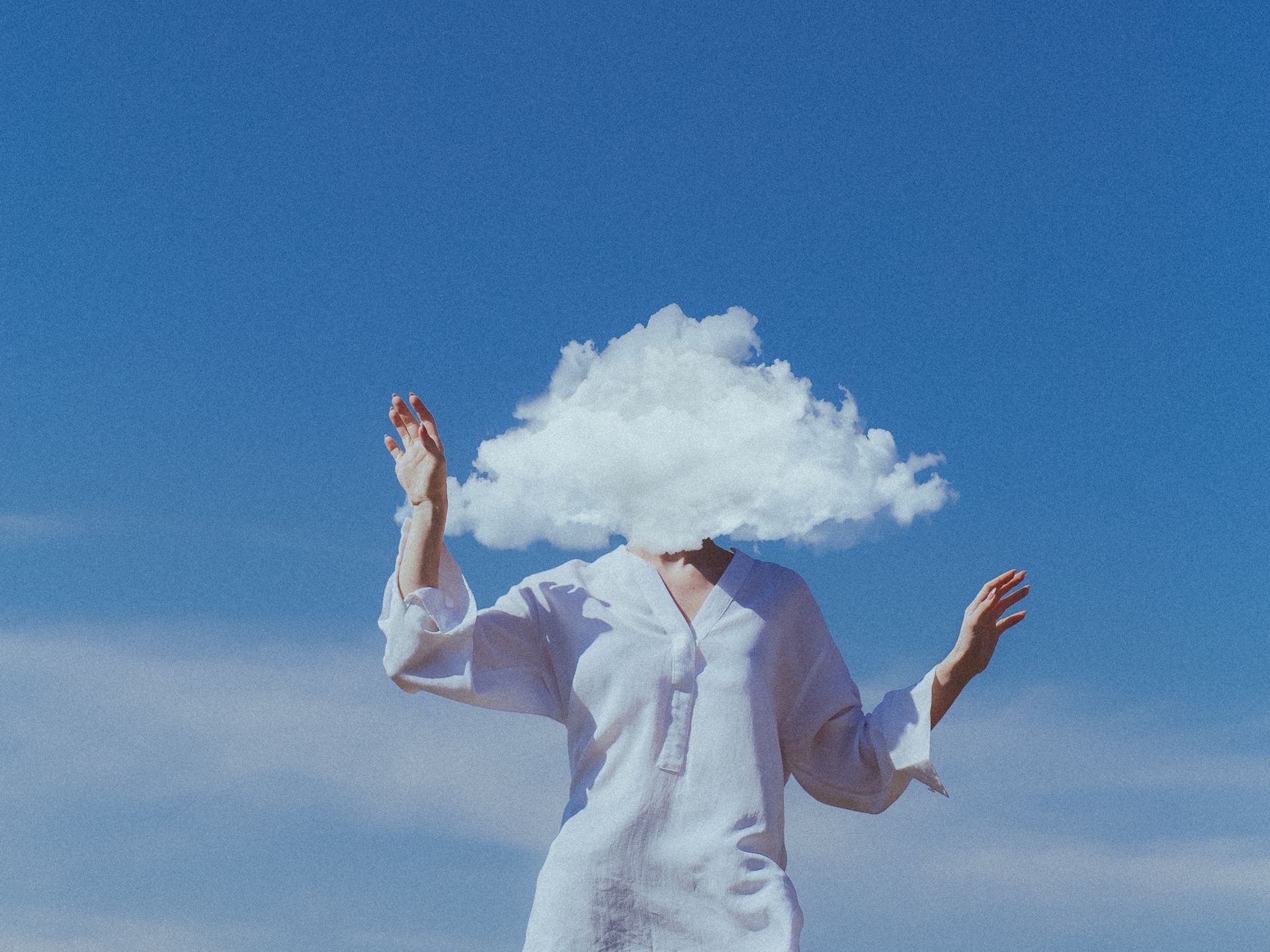 A woman in a white shirt has a cloud on her head.