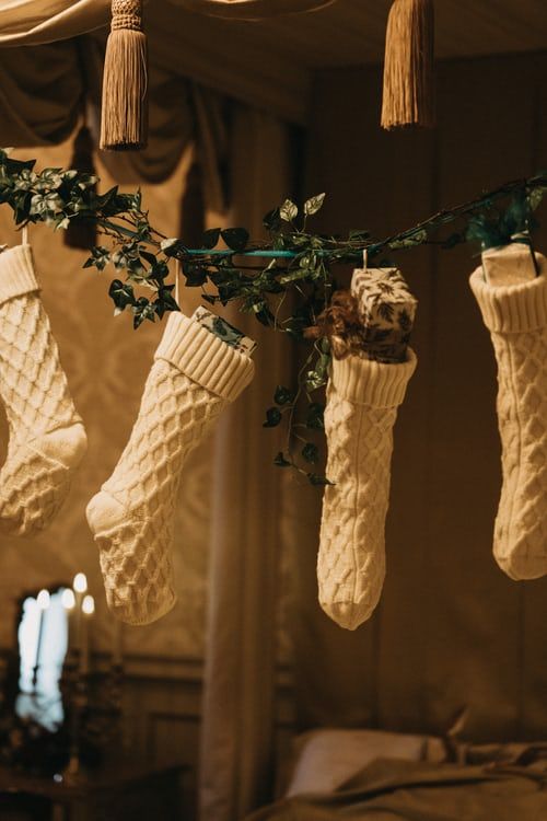 christmas stockings are hanging from a canopy in a bedroom .