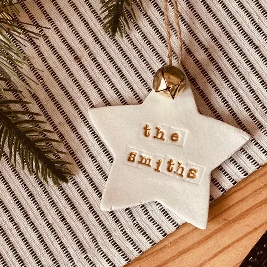 A white star shaped christmas ornament personalised with the name the smiths written on it.