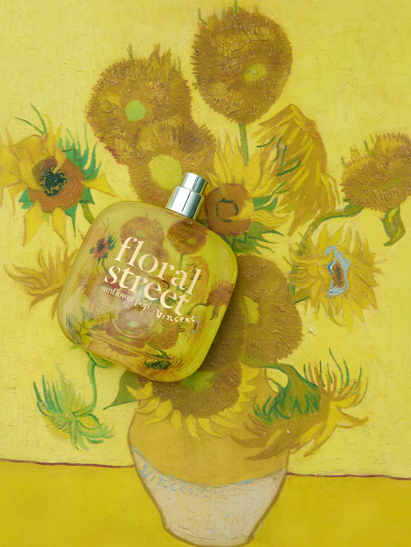 a bottle of Floral Street perfume is sitting on top of a painting of sunflowers .