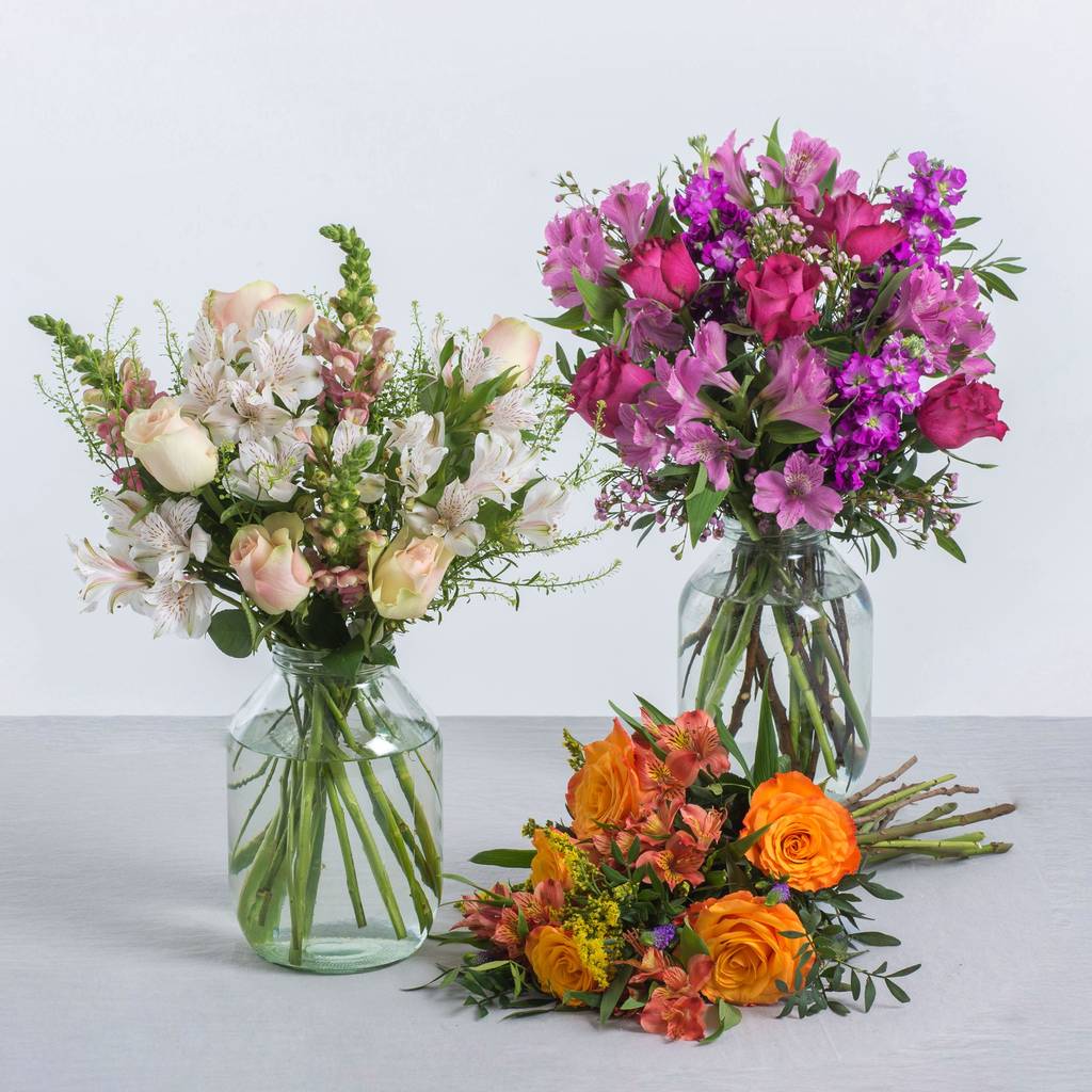 Two vases filled with flowers are sitting on a table.