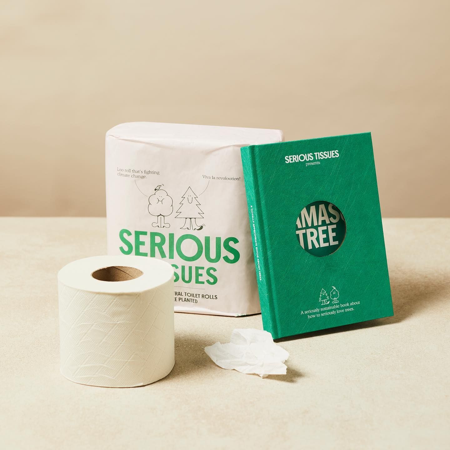 a roll of toilet paper next to a book titled xmas tree