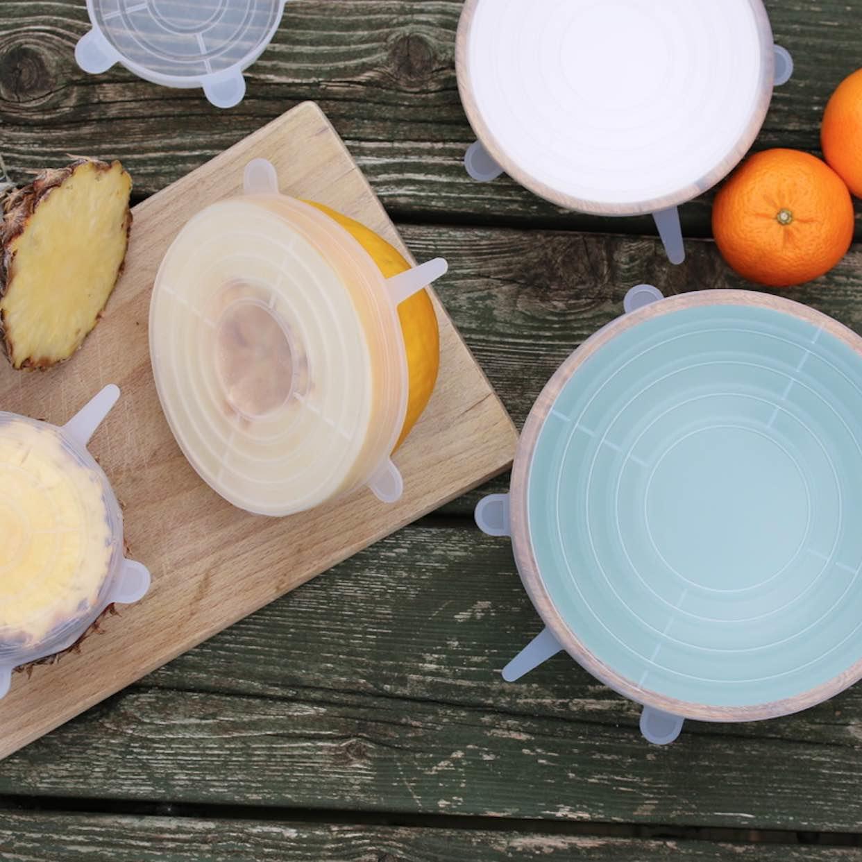 A cutting board with a slice of pineapple and a bowl of food on it