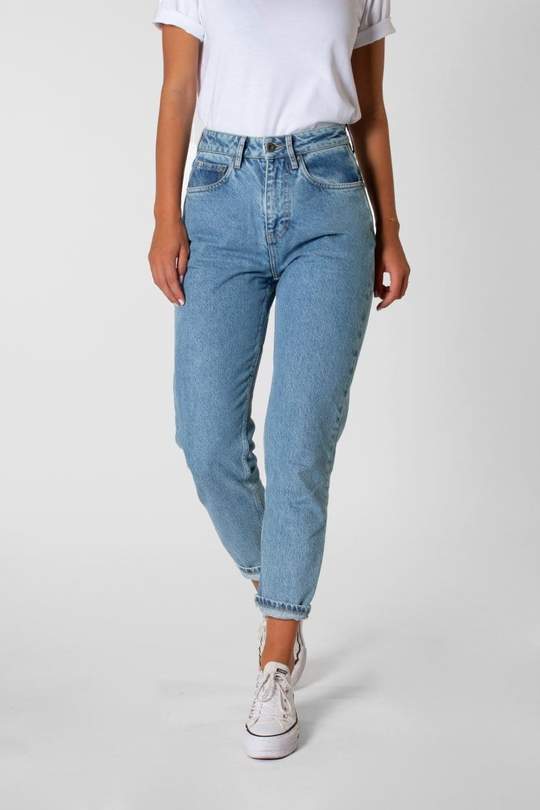 A woman is wearing a white t-shirt and light blue jeans.