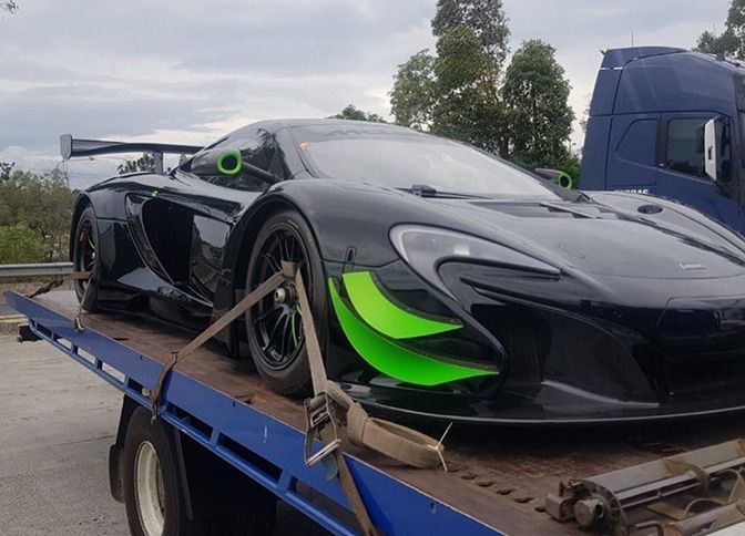 A Black and Green Sports Car is Sitting on Top of a Tow Truck — Mick’s Towing Service Pty Ltd in Carrara, QLD