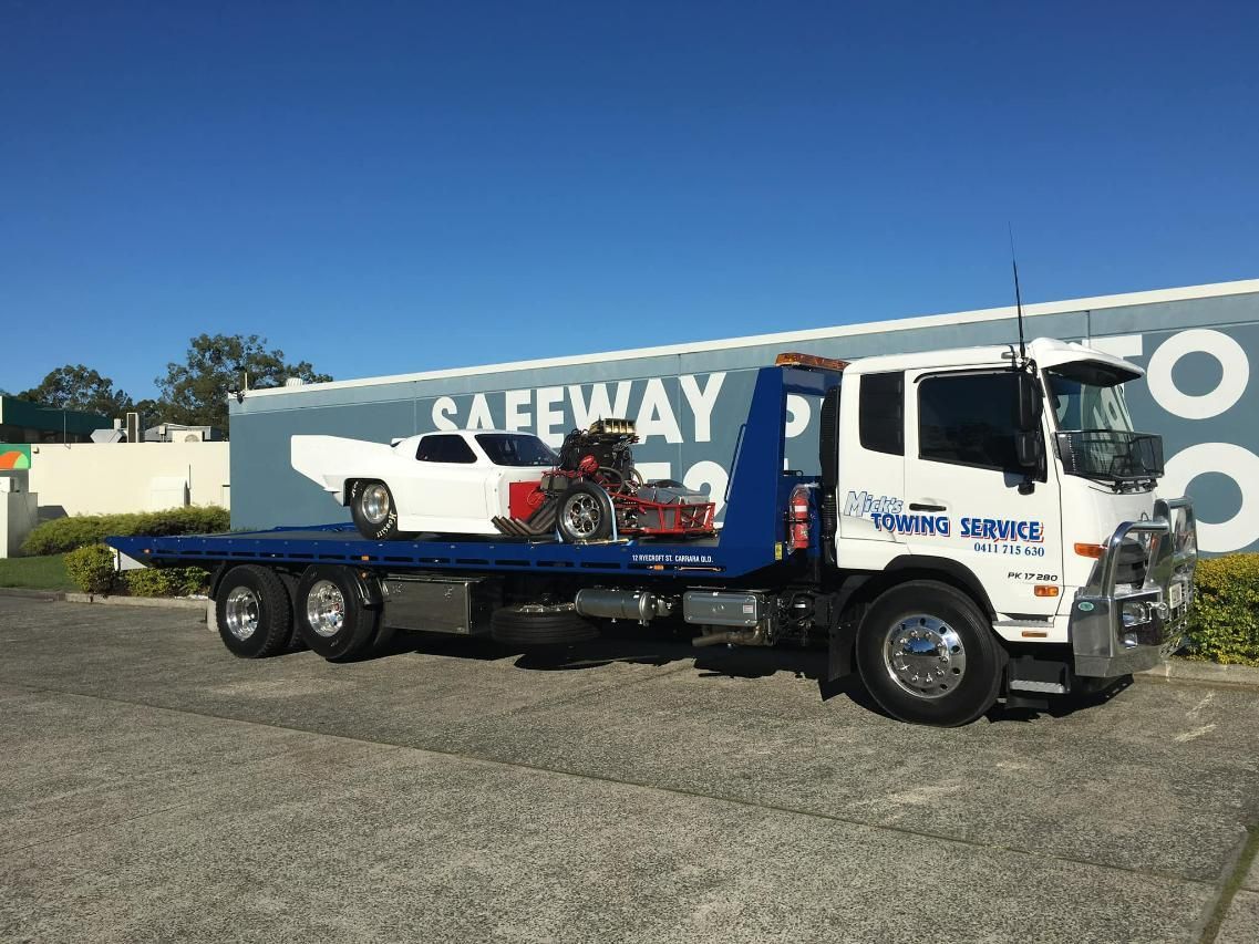 A Tow Truck With a Car and Motorcycle on the Back — Mick's Towing Service Pty Ltd in Carrara, QLD