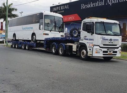 A Bus is Being Towed by a Tow Truck — Mick’s Towing Service Pty Ltd in Carrara, QLD