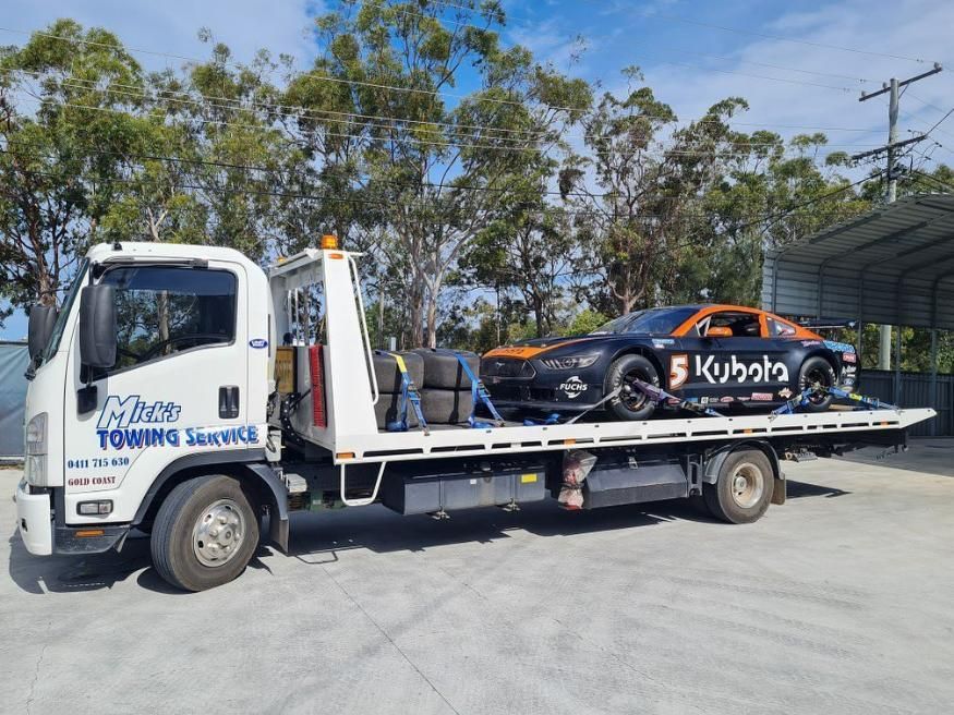 A Tow Truck with A Race Car on The Back of It — Mick's Towing Service Pty Ltd in Carrara, QLD