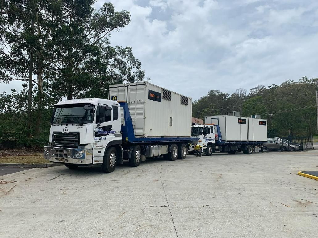 Two Trucks Are Parked Next to Each Other in A Parking Lot — Mick's Towing Service Pty Ltd in Carrara, QLD