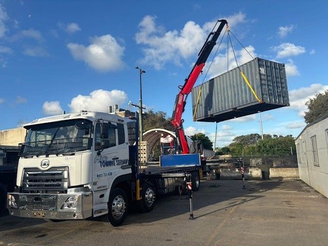 A Large Truck With a Crane on the Back is Parked on the Side of the Road — Mick's Towing Service Pty Ltd in Carrara, QLD