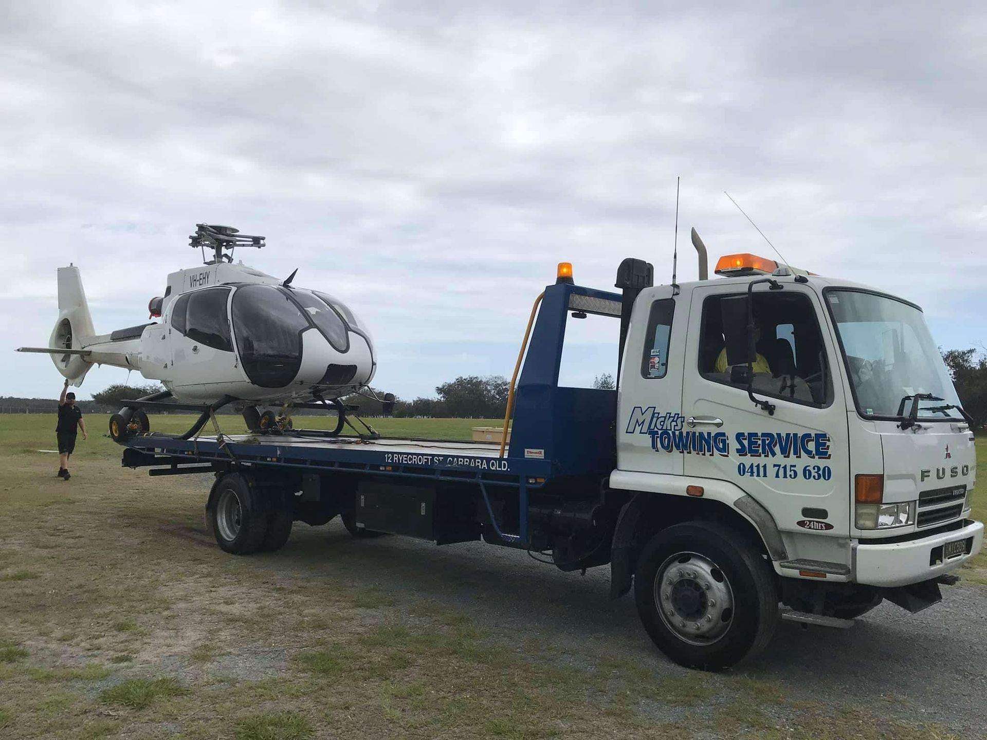 A Helicopter is Being Towed by a Tow Truck — Mick’s Towing Service Pty Ltd in Carrara, QLD