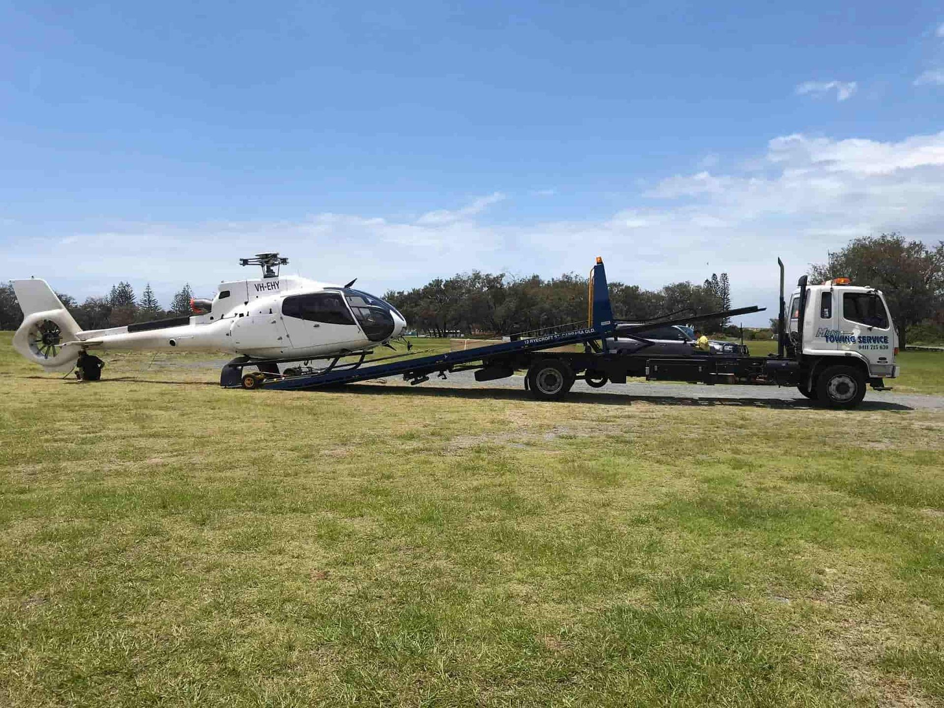A Helicopter is Being Towed by a Tow Truck — Mick’s Towing Service Pty Ltd in Carrara, QLD