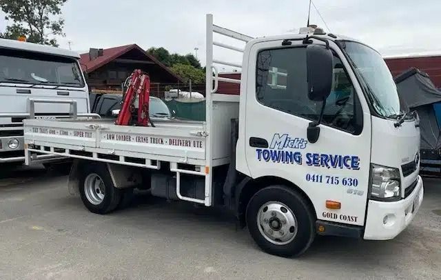 A White Towing Service Truck is Parked in a Parking Lot — Mick's Towing Service Pty Ltd in Carrara, QLD