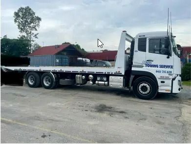 A White Tow Truck is Parked in a Parking Lot — Mick's Towing Service Pty Ltd in Carrara, QLD