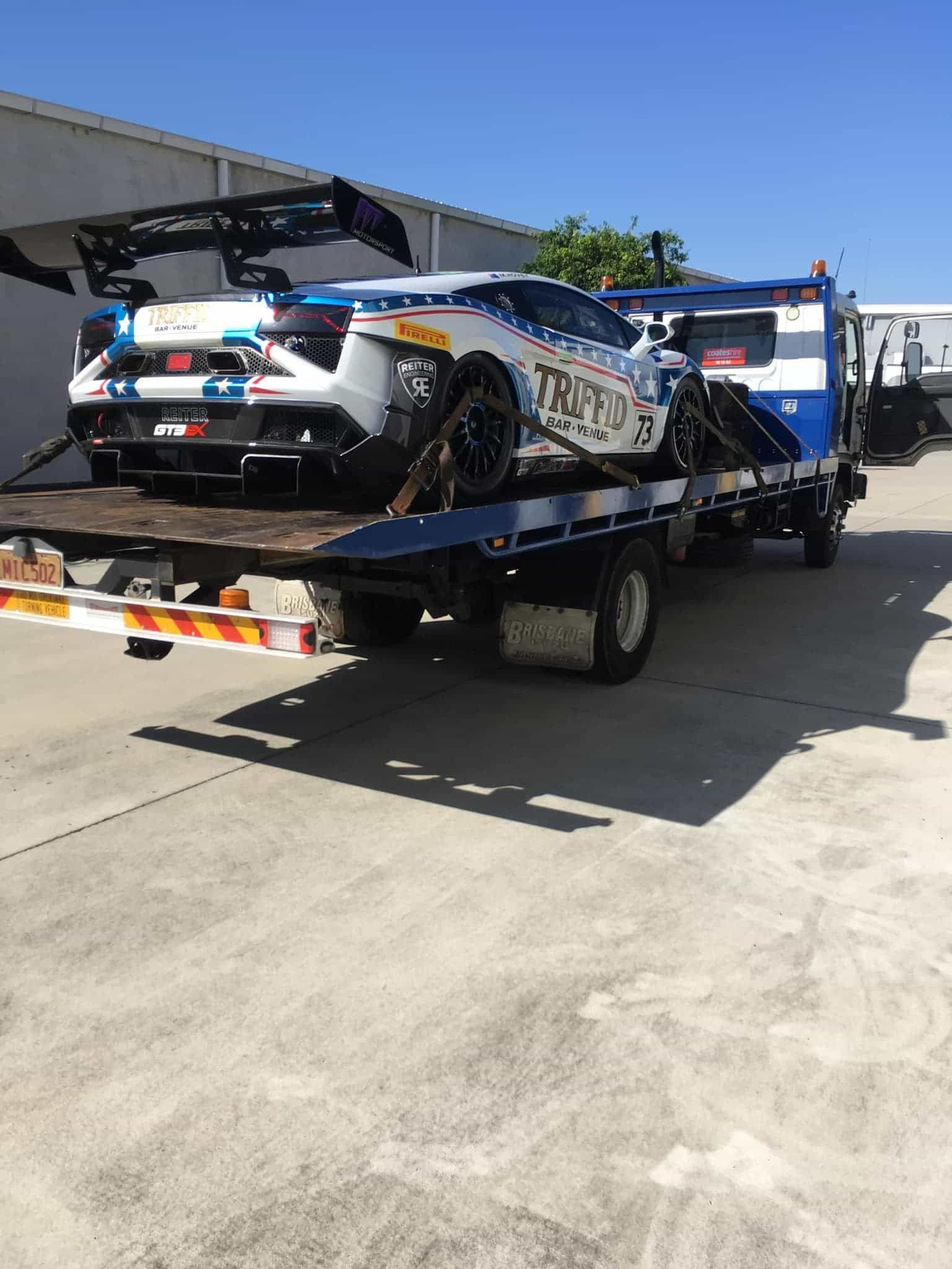 A Car is Being Towed by a Tow Truck — Mick's Towing Service Pty Ltd in Carrara, QLD