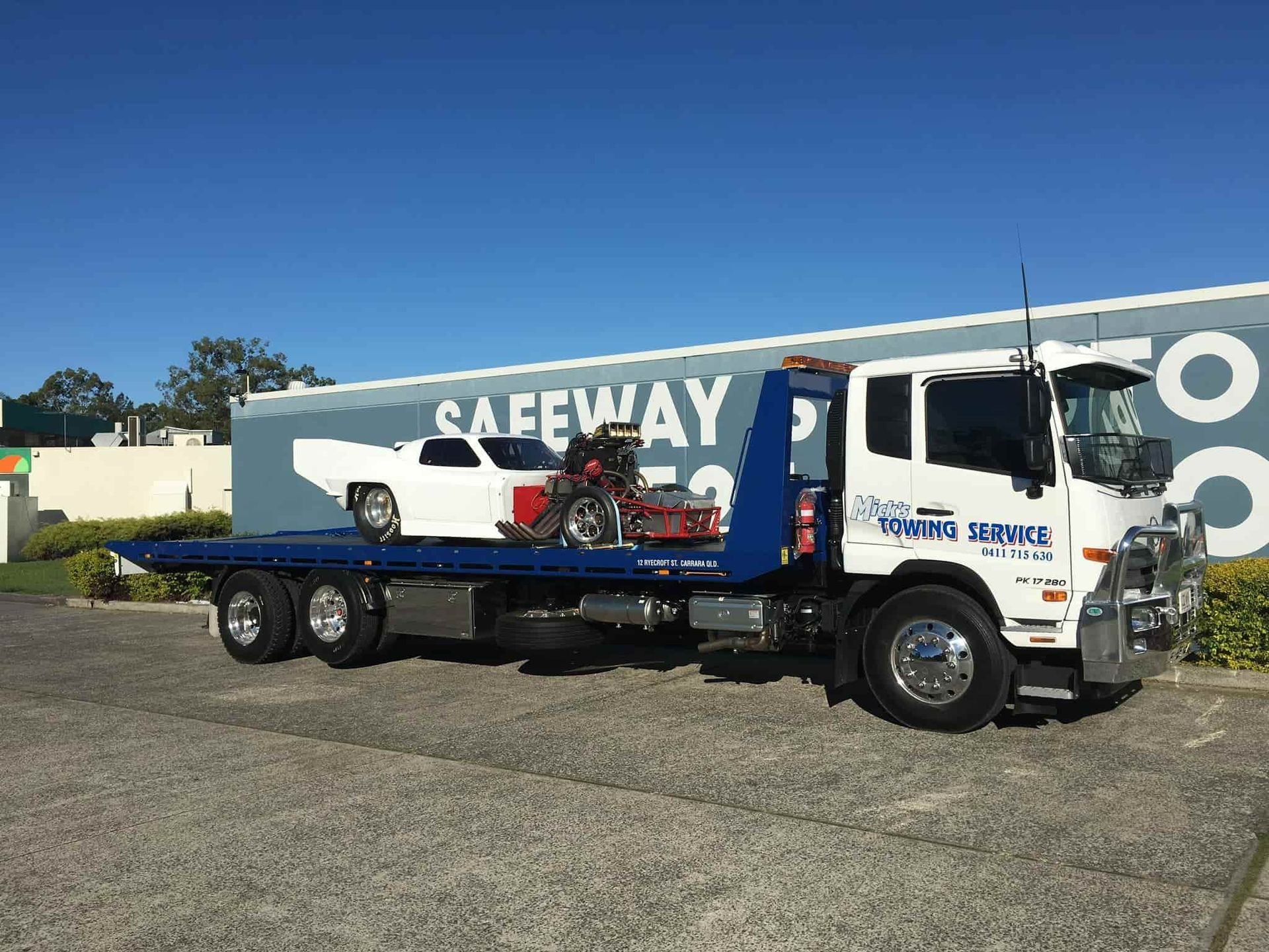 A Tow Truck is Towing a Car and a Motorcycle  — Mick's Towing Service Pty Ltd in Carrara, QLD