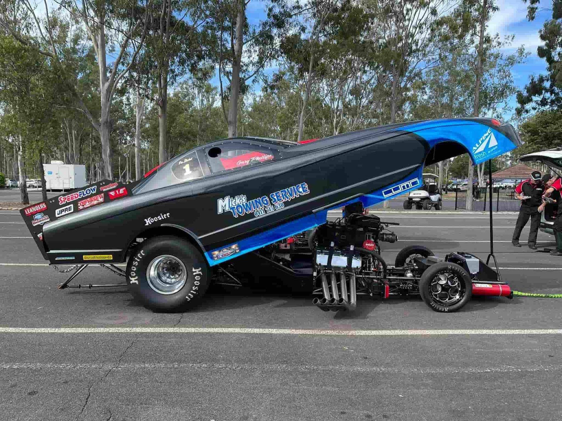 A Black and Blue Racing Car is Parked on the Side of the Road — Mick's Towing Service Pty Ltd in Carrara, QLD