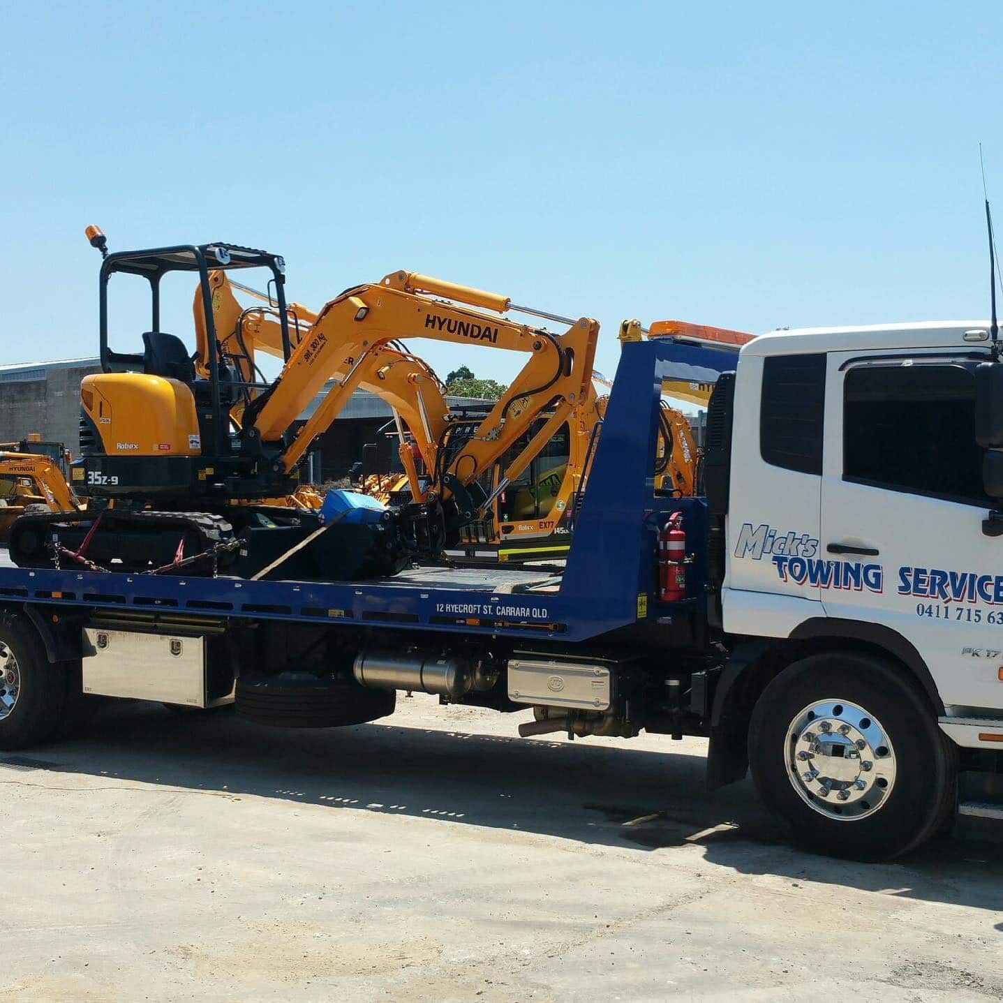A Hyundai Excavator is on the Back of a Towing Service Truck — Mick’s Towing Service Pty Ltd in Carrara, QLD
