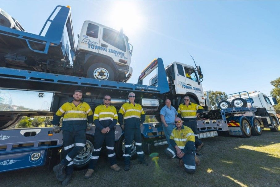 A Group of Men in Front of a Tow Truck — Mick’s Towing Service Pty Ltd in Carrara, QLD