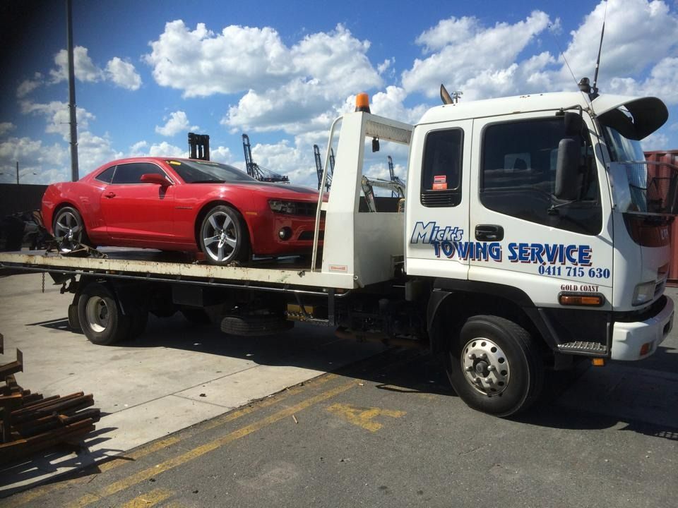 A Red Car is on the Back of a Towing Service Truck — Mick's Towing Service in Carrara, QLD