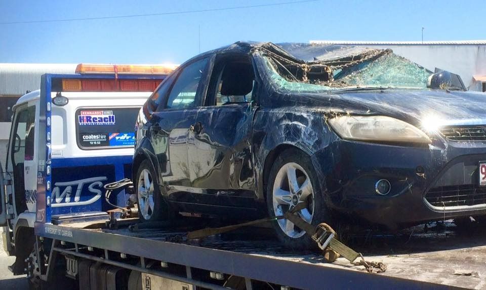 A Black Car With a Broken Windshield is Sitting on Top of a Tow Truck — Mick's Towing Service Pty Ltd in Carrara, QLD