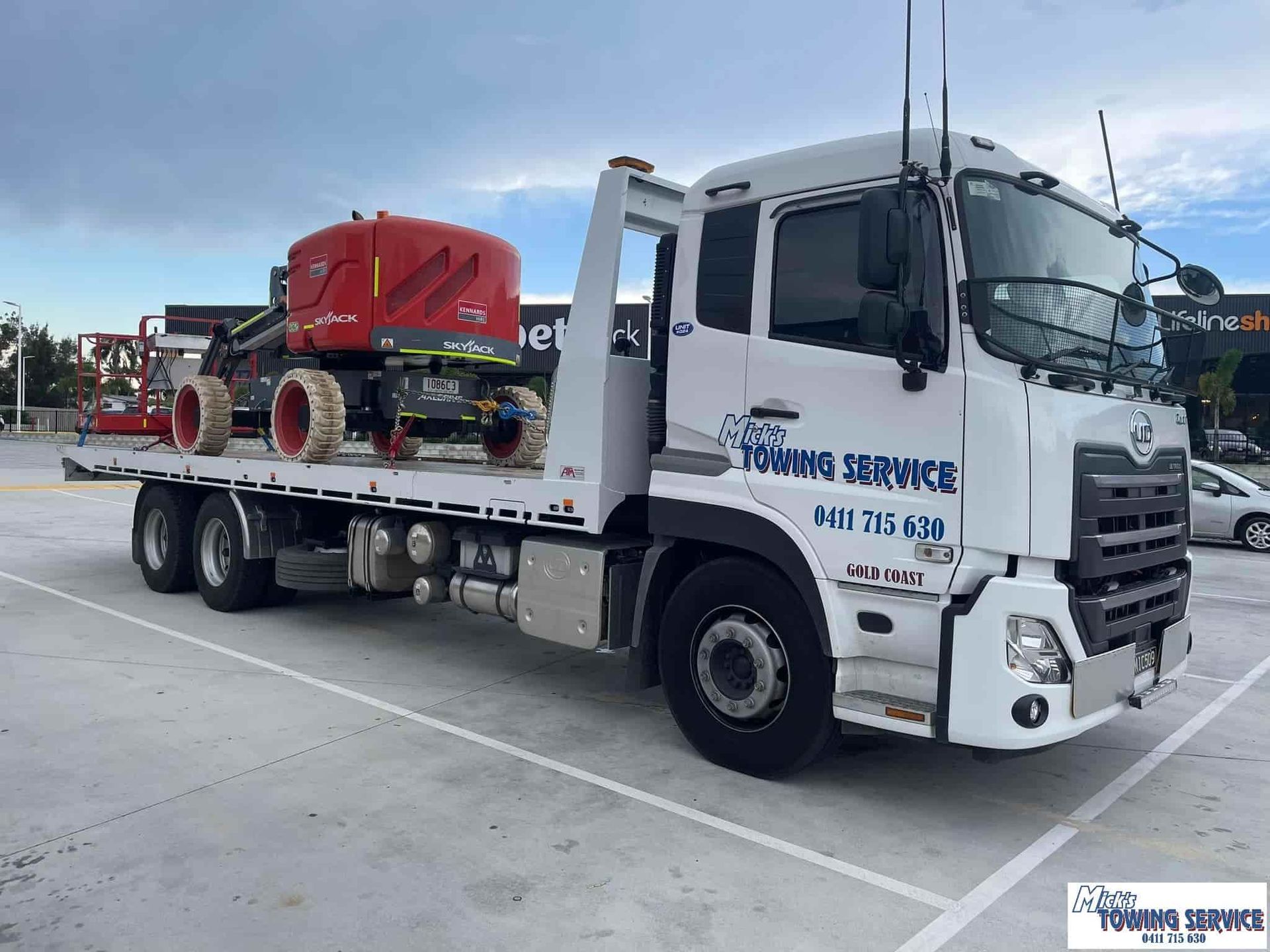White Tow Truck with A Red Lift on The Flatbed Parked Outside — Mick's Towing Service Pty Ltd in Car