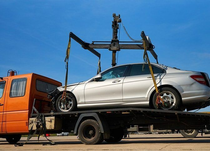 A Car is Being Towed by a Tow Truck — Mick's Towing Service Pty Ltd in Carrara, QLD
