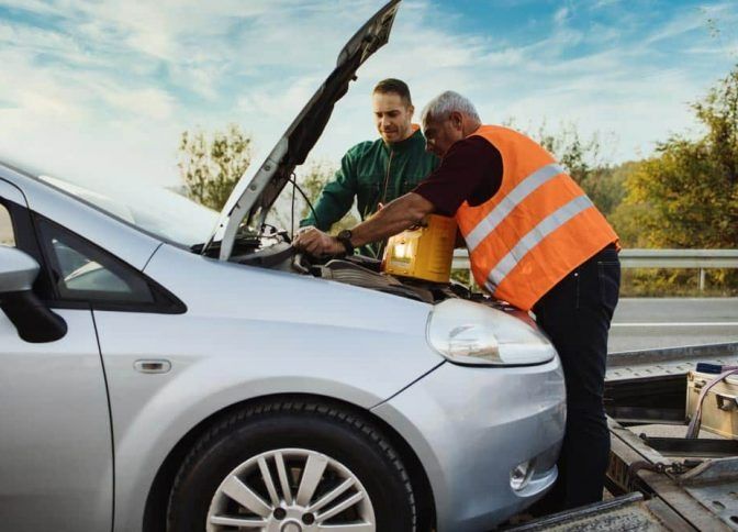 Two Men Are Working on a Broken Down Car on the Side of the Road — Mick's Towing Service Pty Ltd in Carrara, QLD