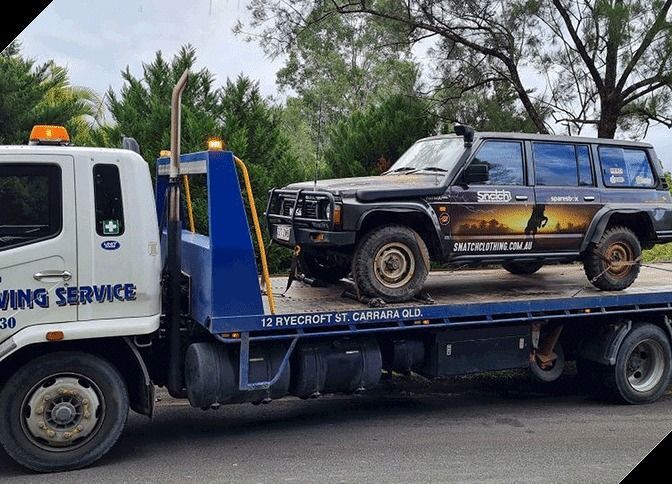 A Tow Truck is Carrying a Jeep on the Back of It — Mick's Towing Service Pty Ltd in Carrara, QLD