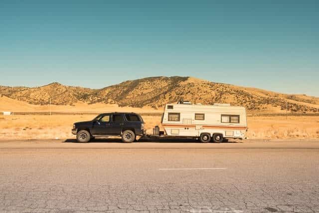 A Car is Towing a Trailer Down a Highway — Mick’s Towing Service Pty Ltd in Carrara, QLD