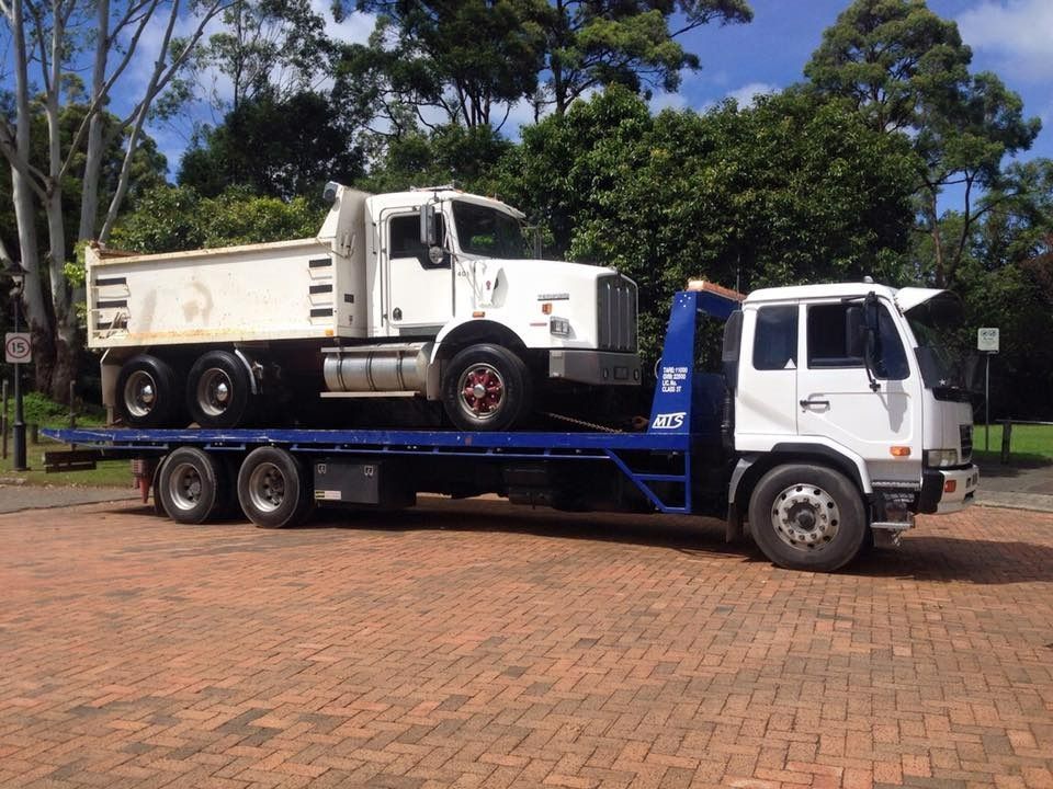 A Tow Truck With a Dump Truck on the Back of It — Mick's Towing Service Pty Ltd in Carrara, QLD