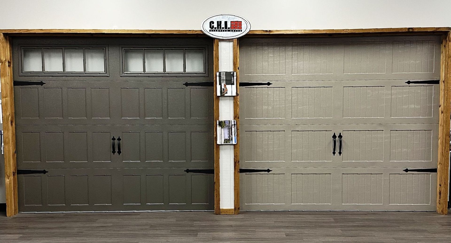 Two garage doors are displayed side by side in a showroom.