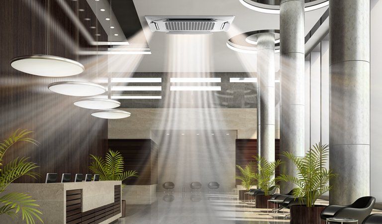 Lobby with air conditioning vent and bright lights, plants, and seating.