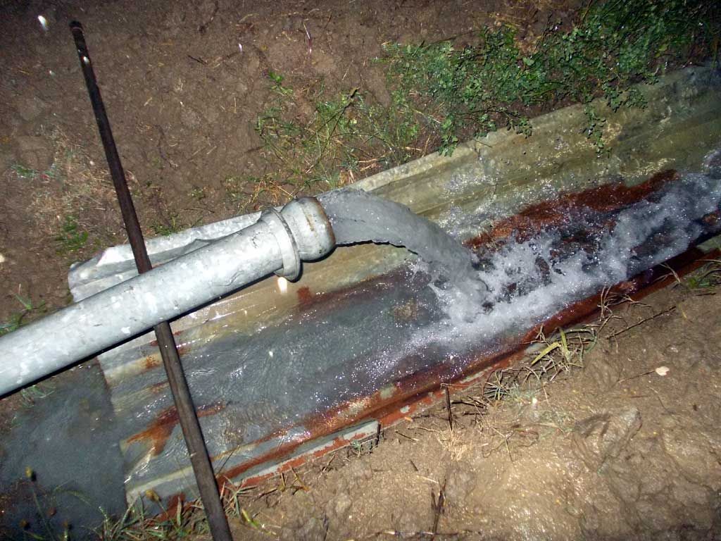 un primo piano di un tubo d' acqua che scorre su un terreno