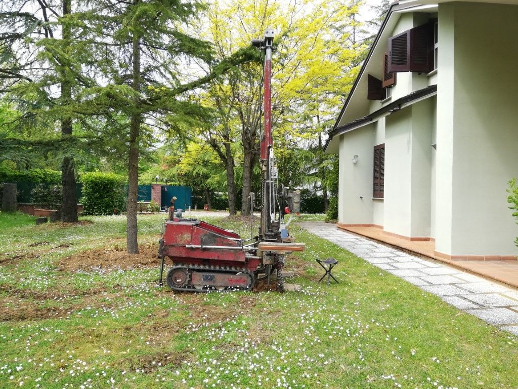macchinario rosso per misurazioni messo davanti a una casa bianca
