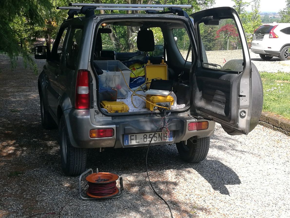 un'auto con il bagagliaio aperto è parcheggiata su una strada di ghiaia