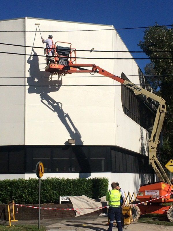 Man Painting the Building — Ingleburn, NSW — Roads & Traffic Management Services