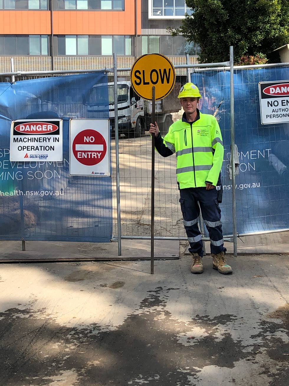 Man Holding Traffic Sign — Ingleburn, NSW — Roads & Traffic Management Services