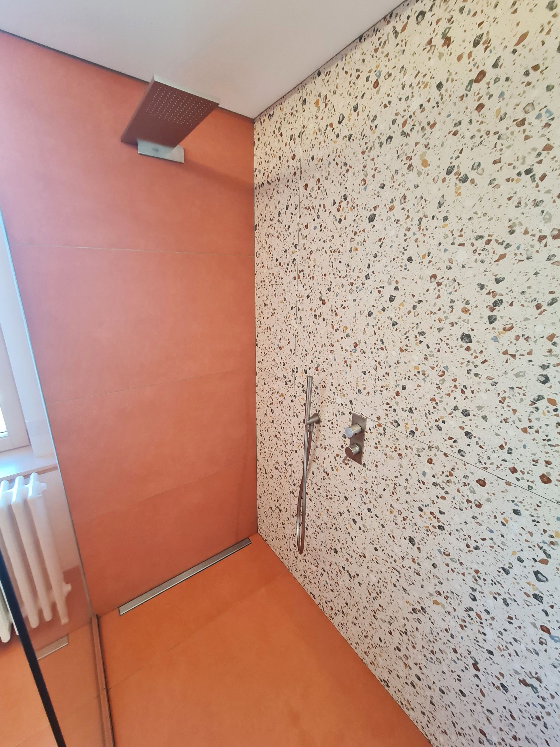 Une salle de bain avec une pomme de douche au mur.