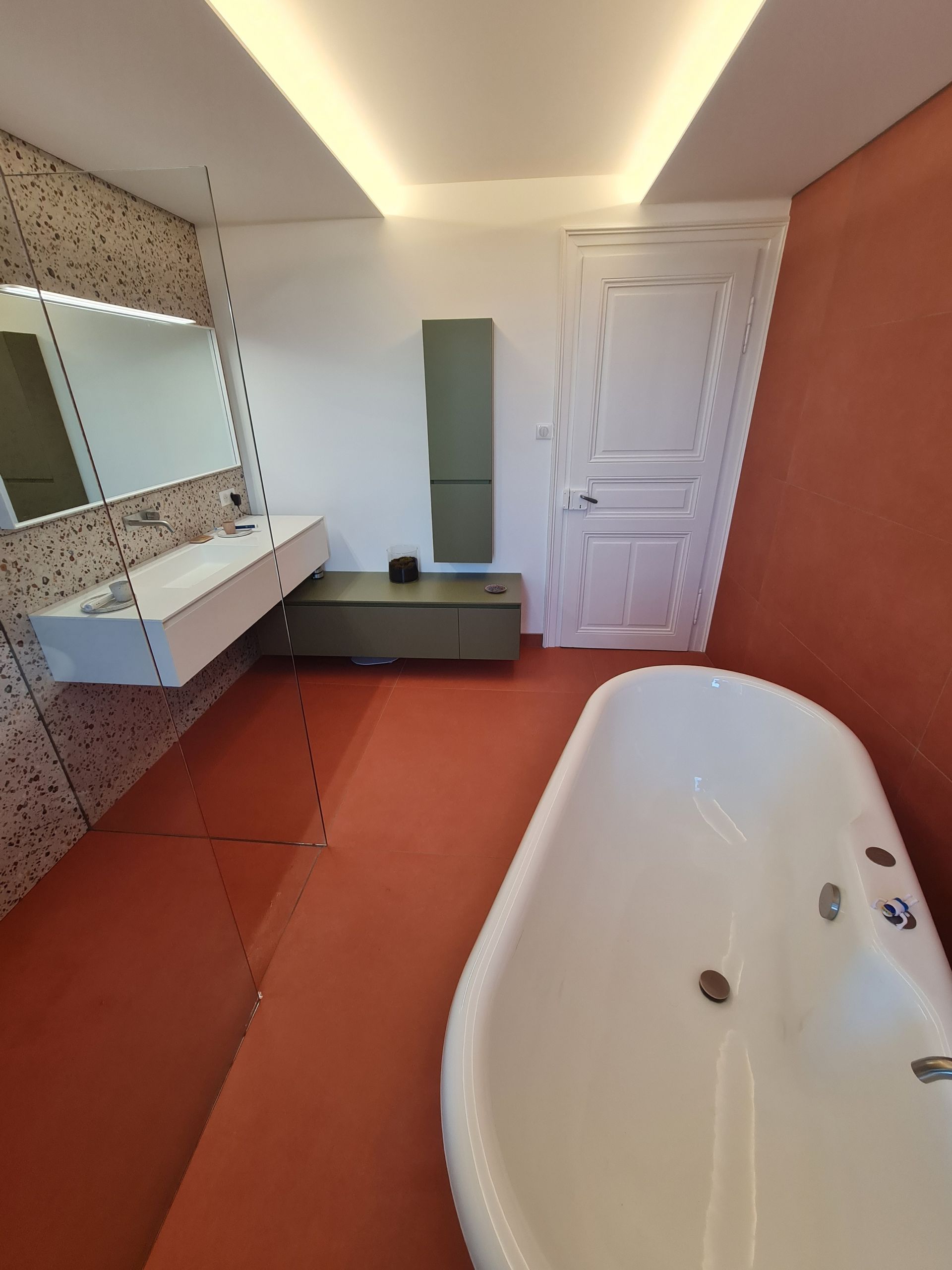 Une salle de bain avec baignoire, lavabo et miroir.