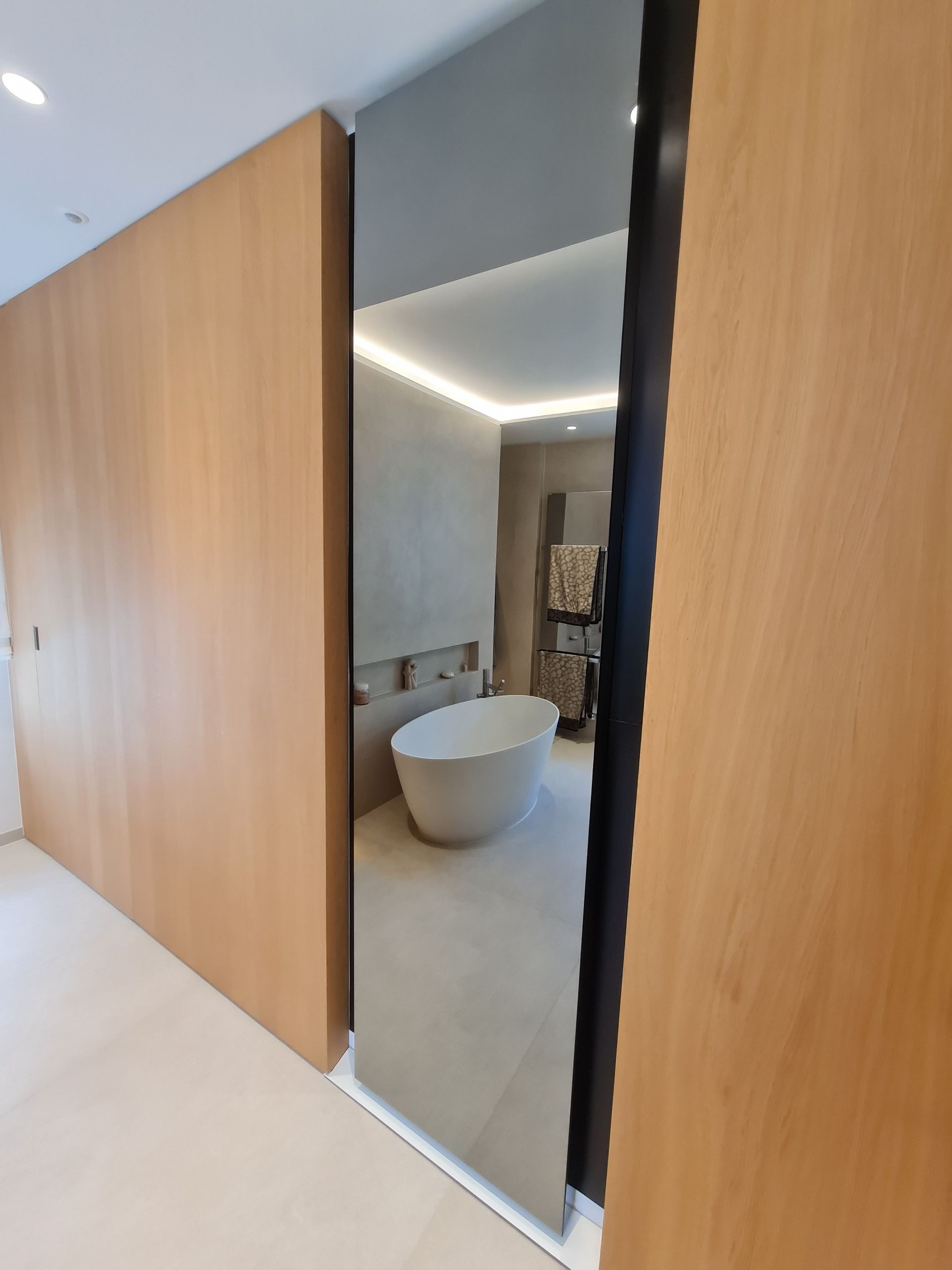 Une salle de bain avec une baignoire et un grand miroir