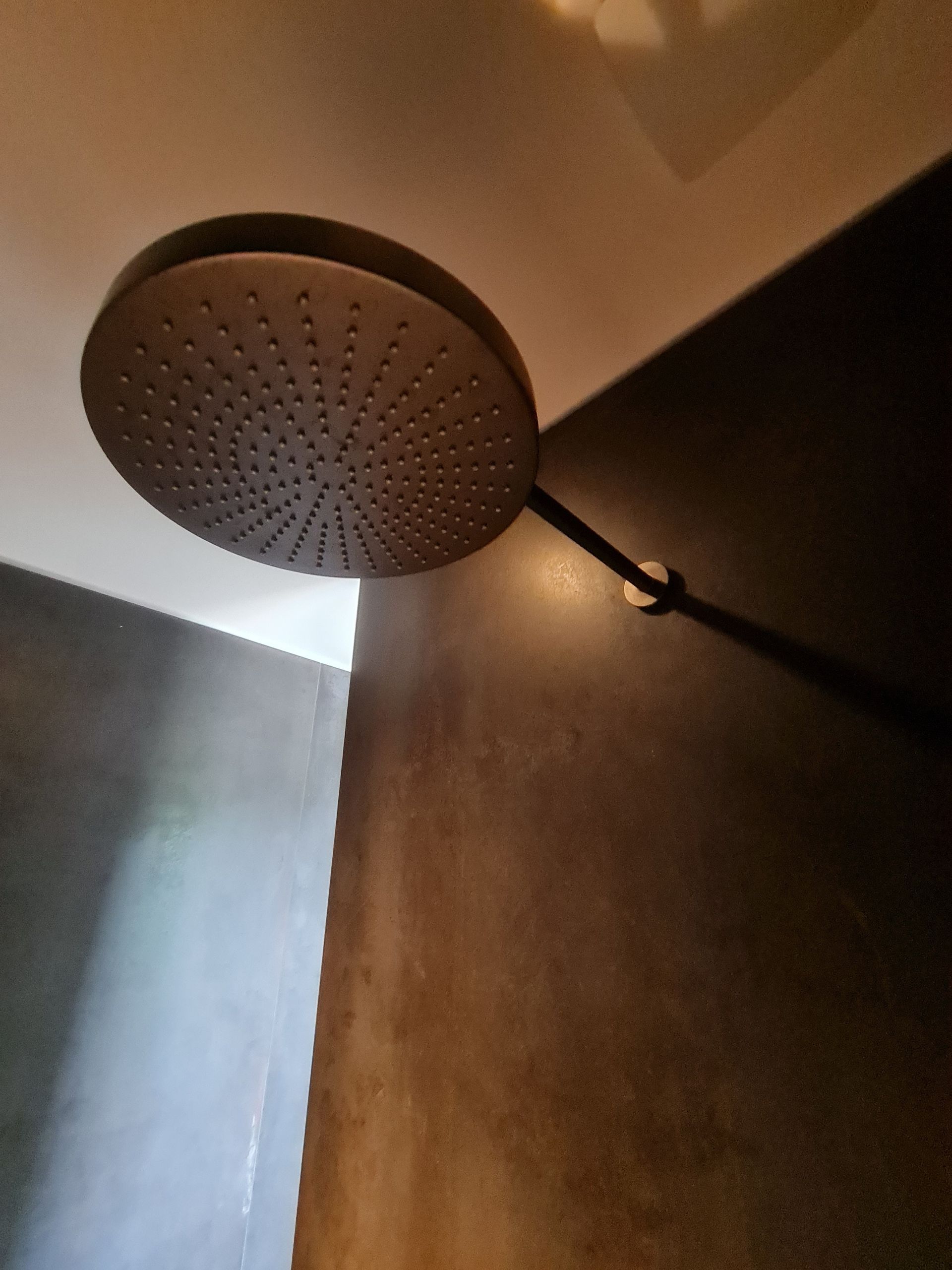 Un gros plan d'une pomme de douche dans une pièce sombre