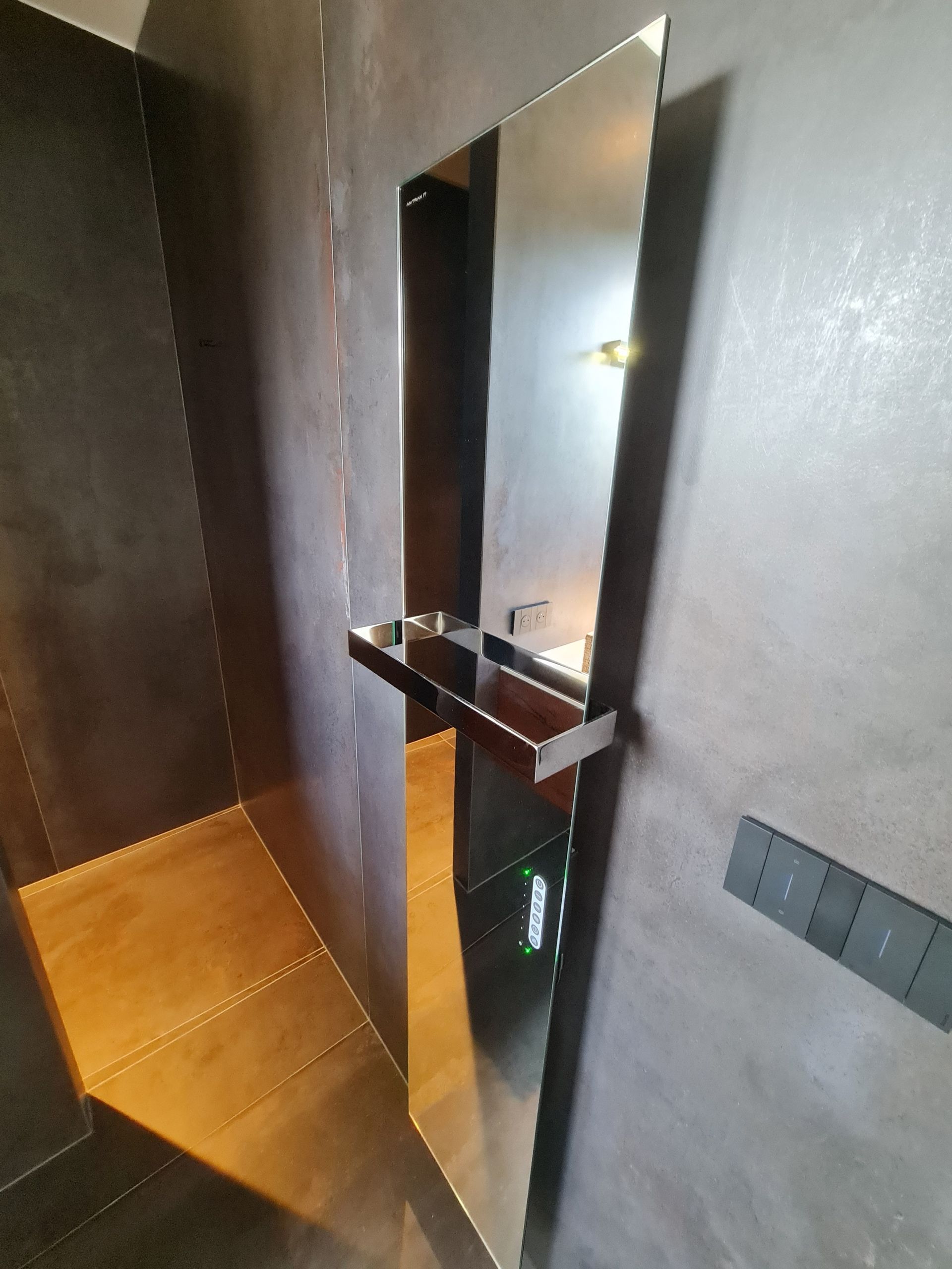 Une salle de bain avec un grand miroir sur le mur