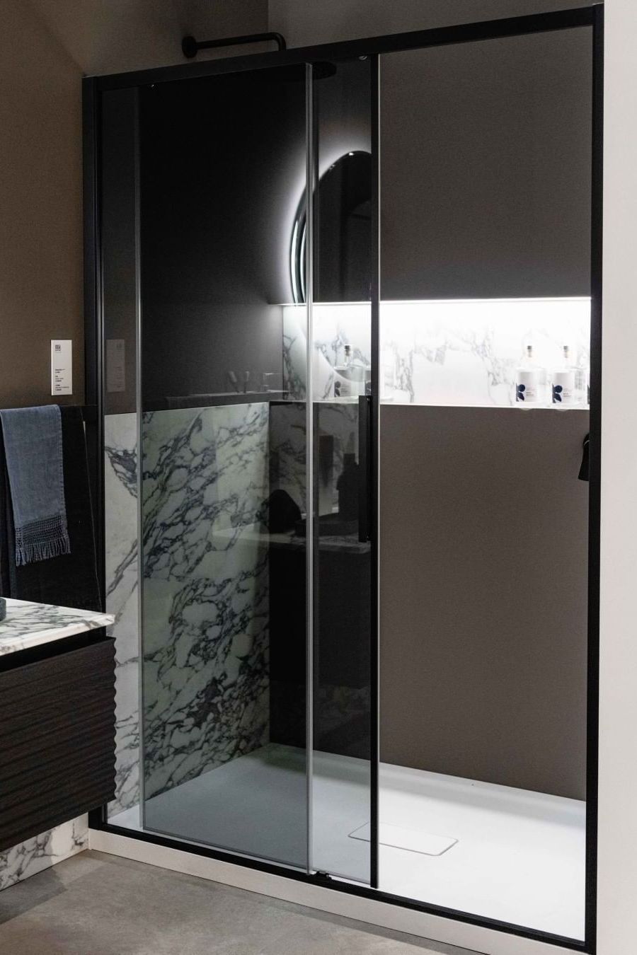 Une salle de bain avec une porte de douche coulissante en verre Disenia, cabine de douche noire, verre fumé