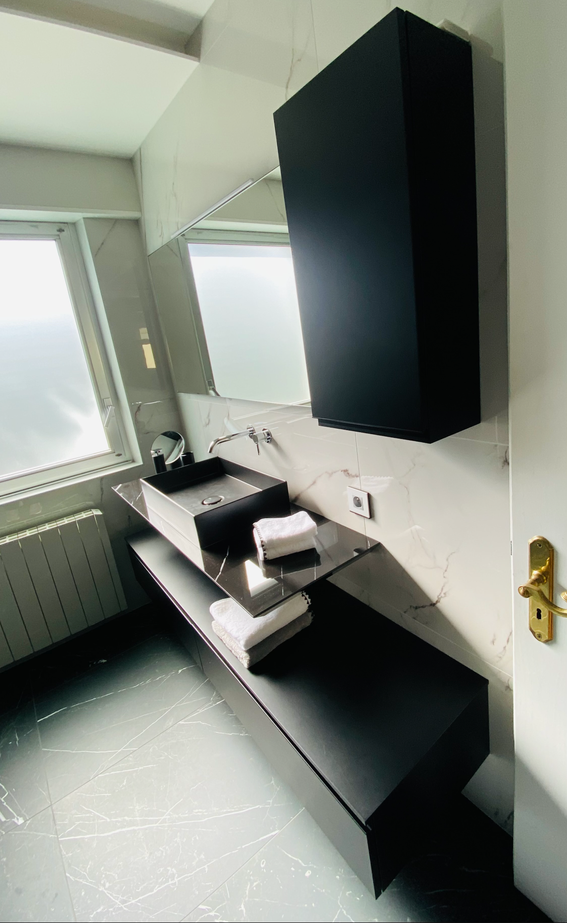 Une salle de bain avec un lavabo, un miroir et un meuble.