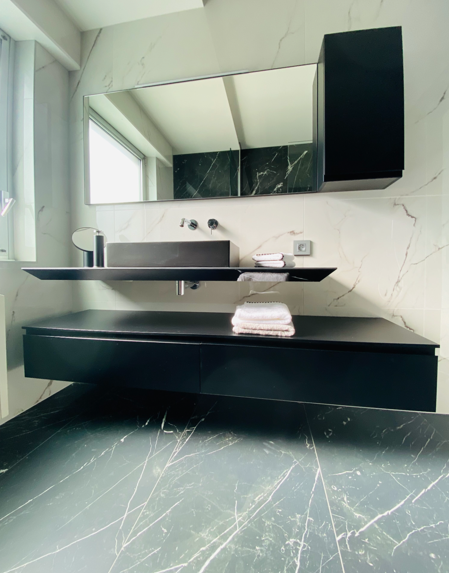 Une salle de bain avec un lavabo et un miroir au mur